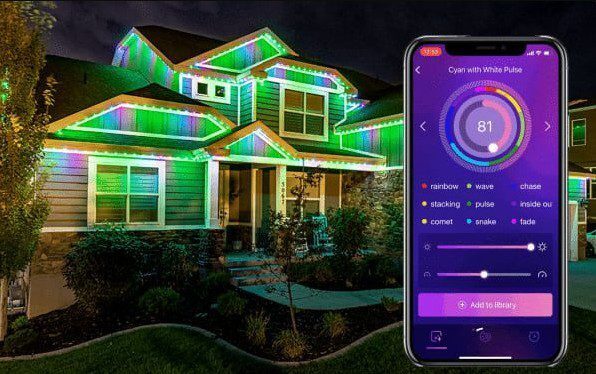 A two-story house decorated with colorful LED lights along the roofline at night. In the foreground, a smartphone displays an app for controlling the lights’ colors and effects. {{brizy_dc_image_alt imageSrc=